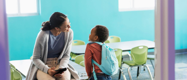 Profesor hablando al niño en el aula azul